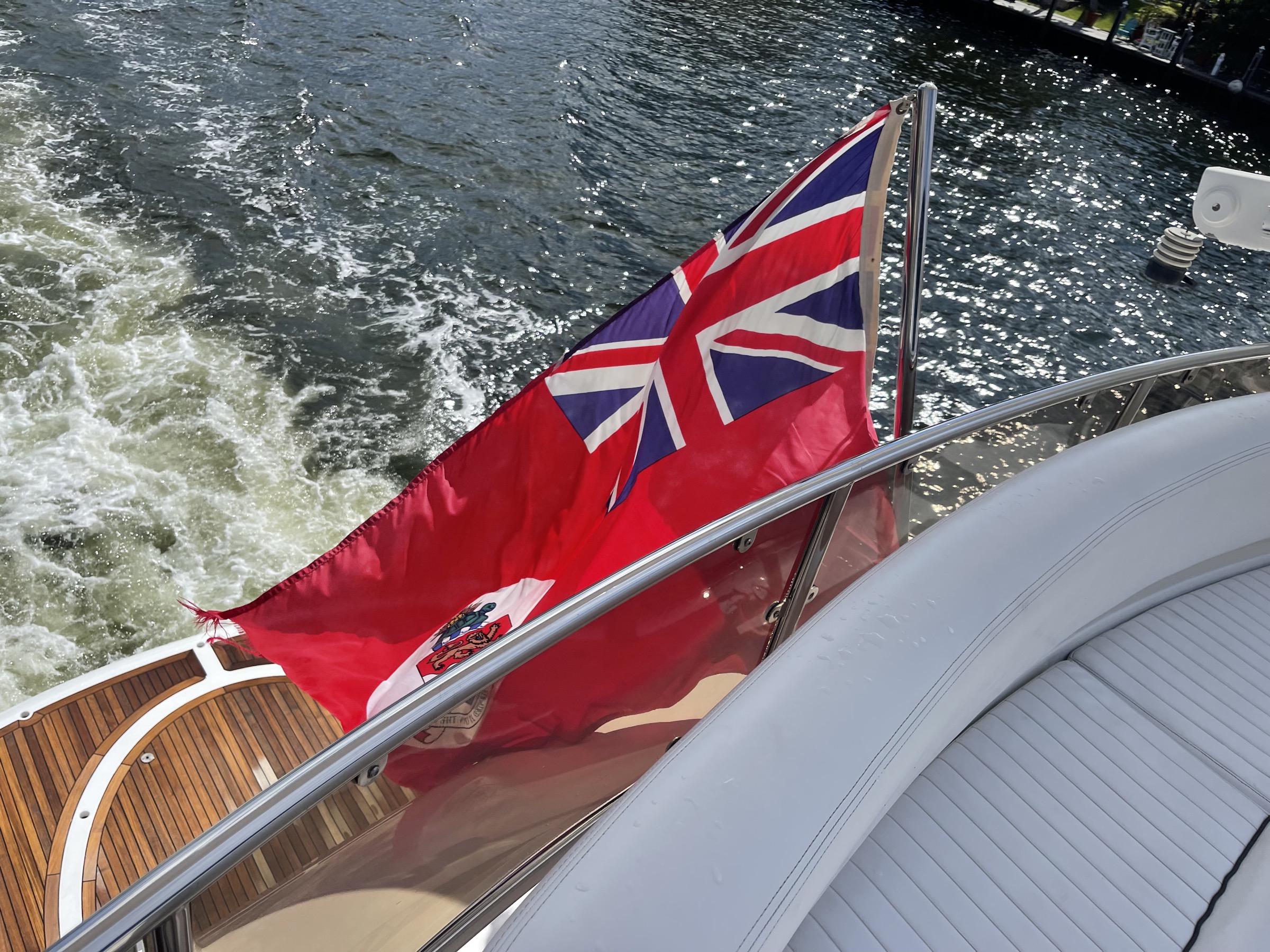 A red ensign flying from the stern of a yacht under way, the flag of a foreign registry