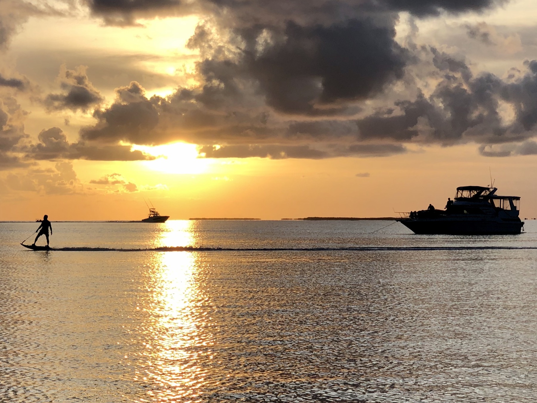 A yacht lying at anchor on calm water at sunset